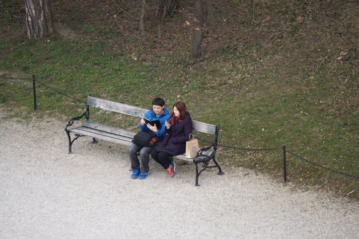 Setelah ngambil beberapa foto, mereka duduk dan mungkin membahas atau memposting hasil jepretannya. Live report.